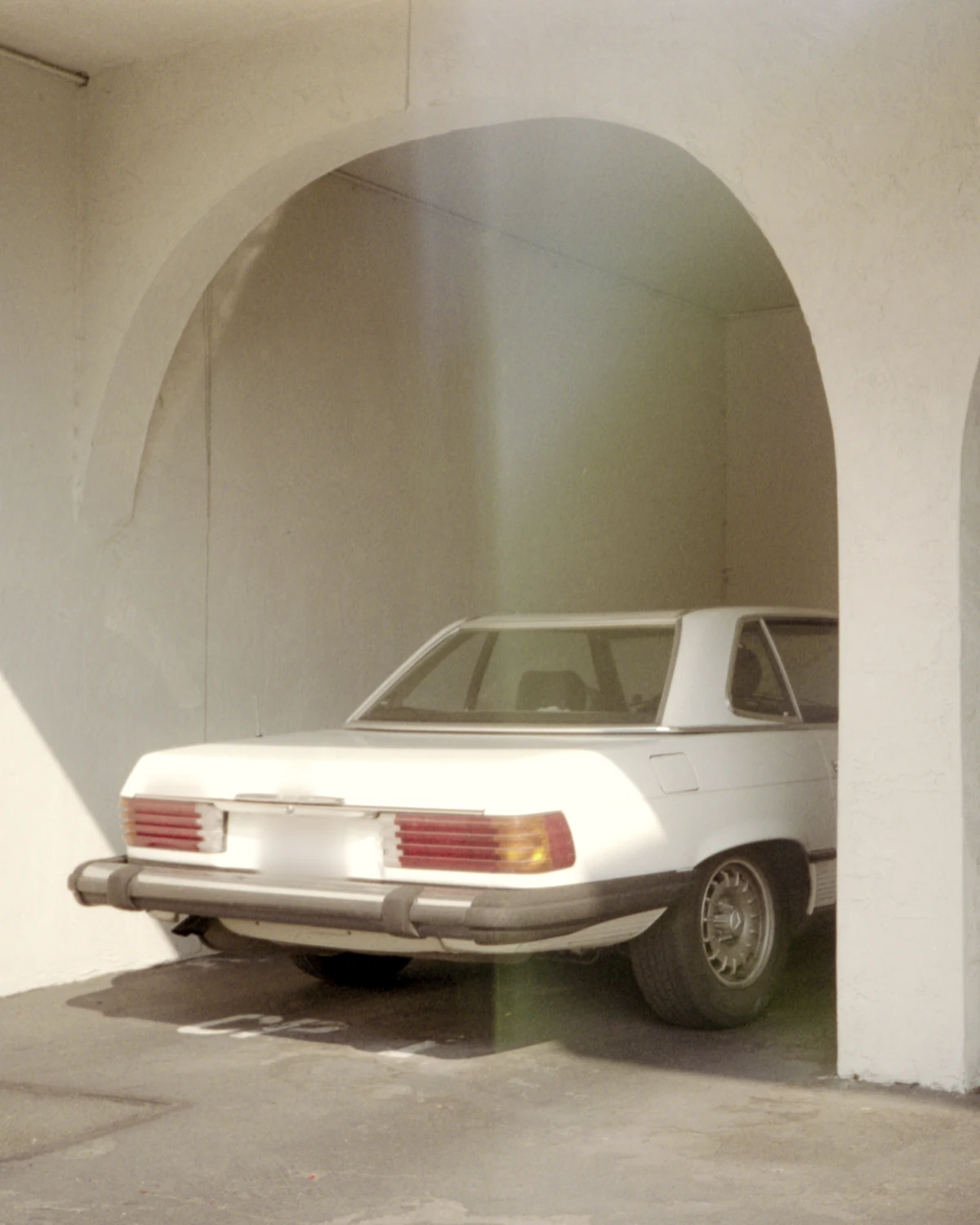 Vintage white roadster under a whitewashed plaster archway